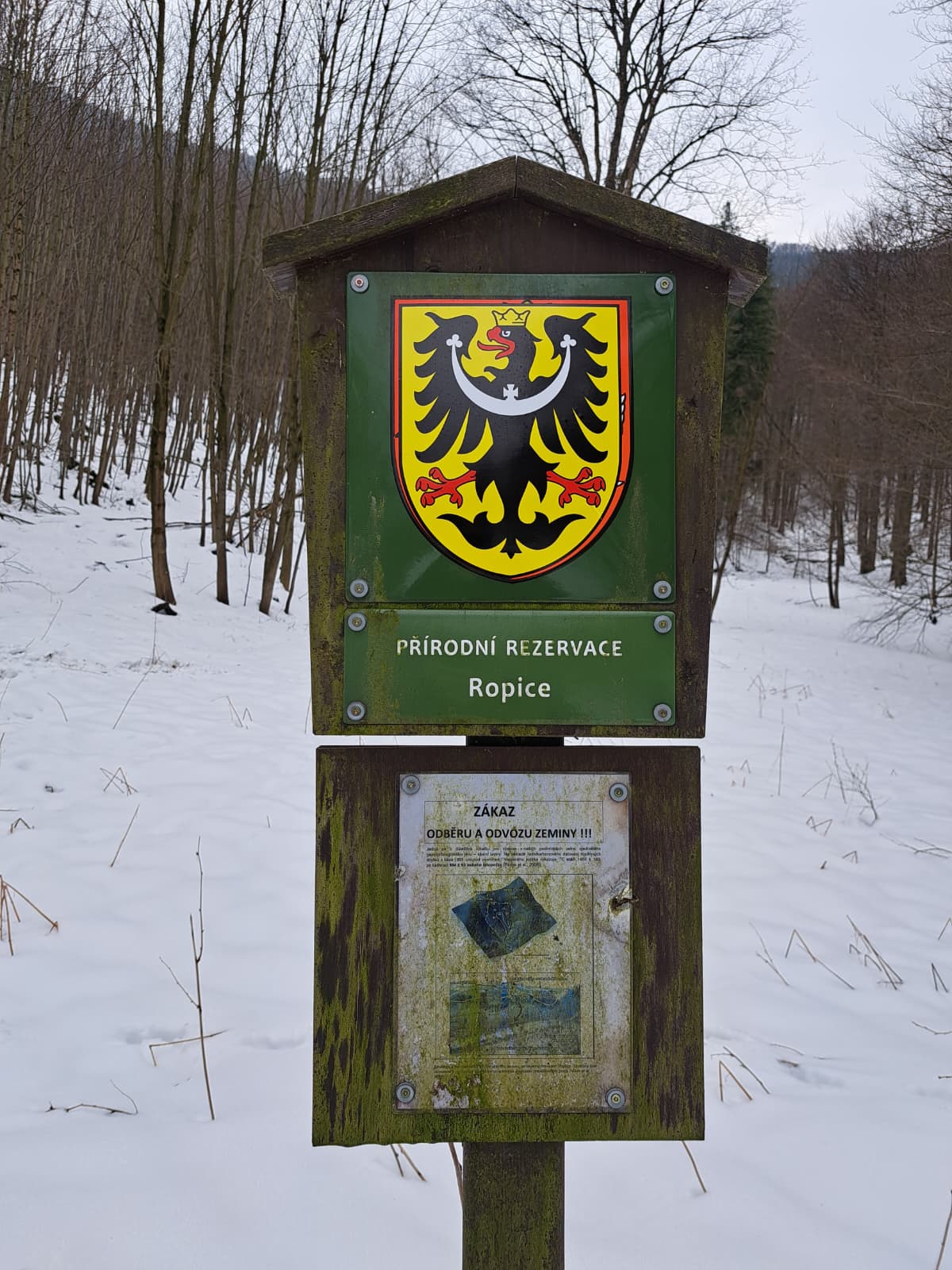 hraničník PR Ropice s malým státním znakem přelepeným slezskou orlicí 