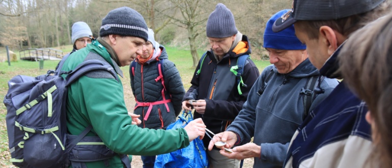 Účastníci vycházky si prohlížejí schránky škeblí.